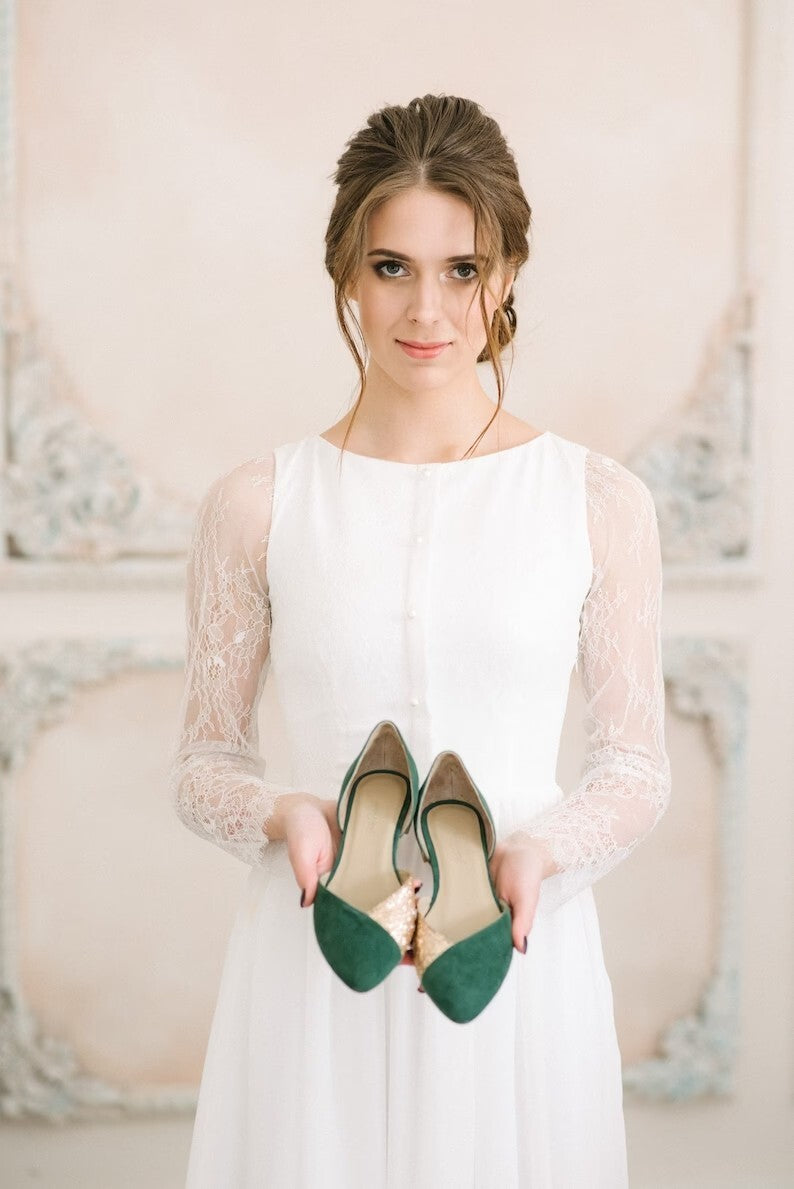 Bride in Anna wedding dress holding a pair of shoes, front view