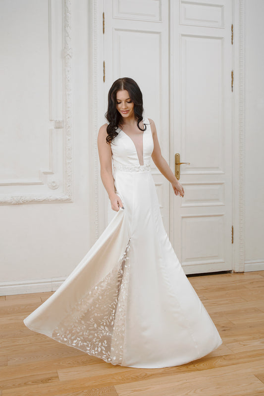 Nina wedding dress with skirt lifted to show leaf-patterned lace inset