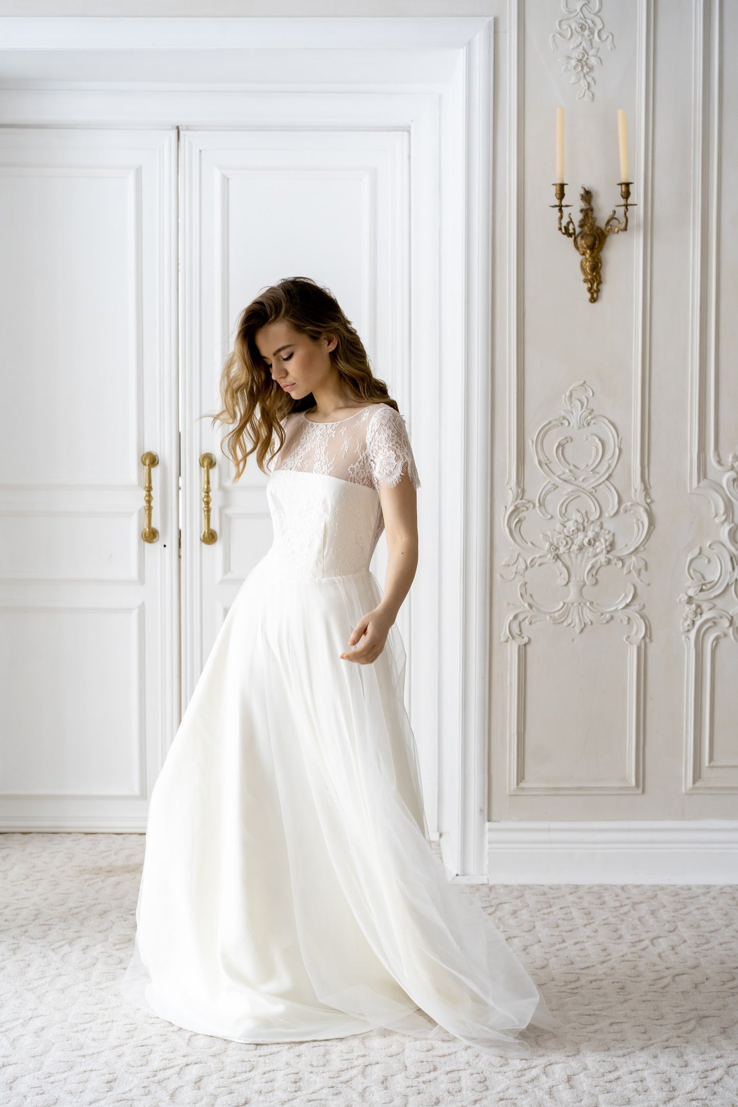 Adele wedding dress front view in an ornate interior, lace top and tulle skirt