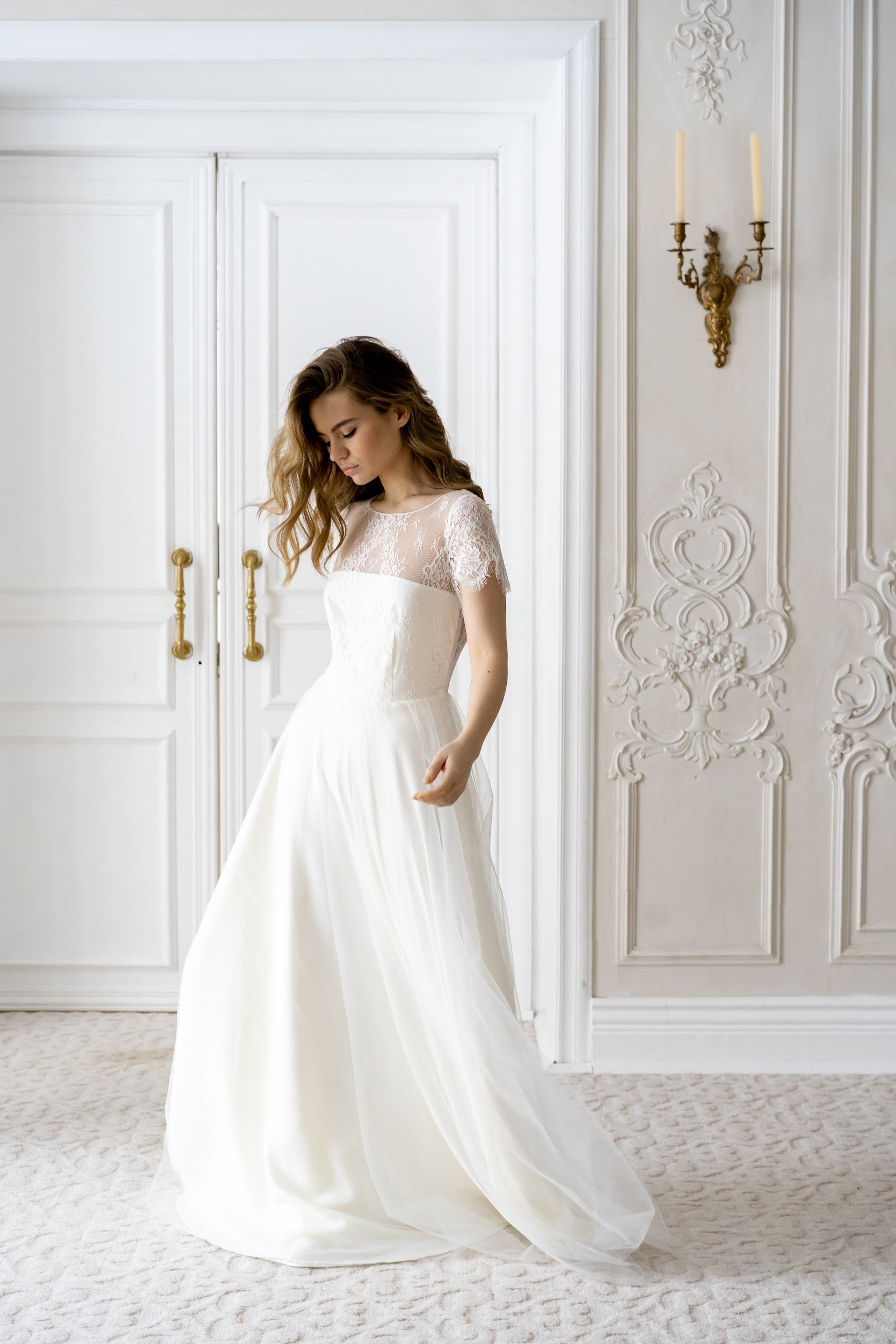 Adele wedding dress front view in an ornate interior, lace top and tulle skirt