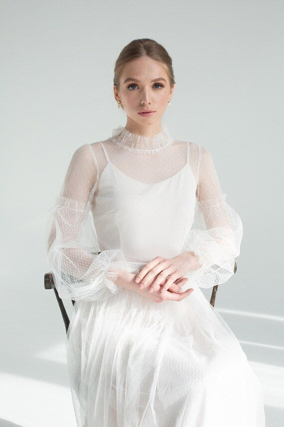Aglaya wedding dress seated, showing sheer dotted-tulle overlay and satin slip