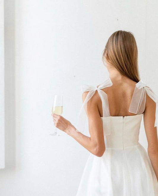 Back of a midi tulle wedding dress with sheer tie-bow straps