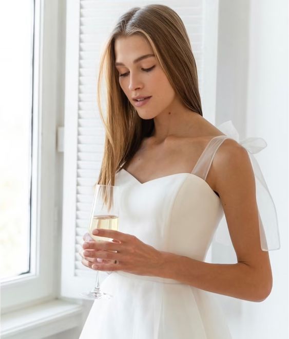 Bride in a midi tulle wedding dress with a sweetheart satin bodice and tie straps

