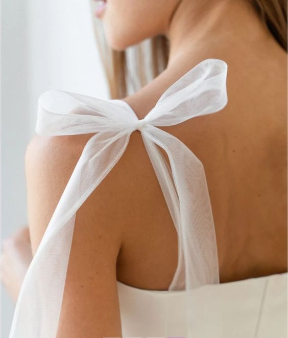 Sheer tulle tie-bow strap detail on a wedding dress shoulder