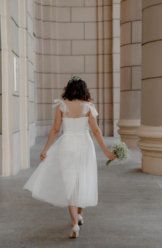 Back view of a tea-length tulle wedding dress with tie straps