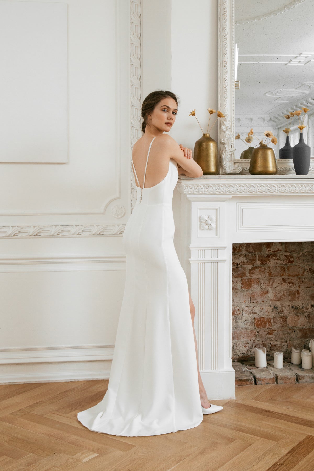 Back view of a fishtail wedding dress with a low open back and crossed straps