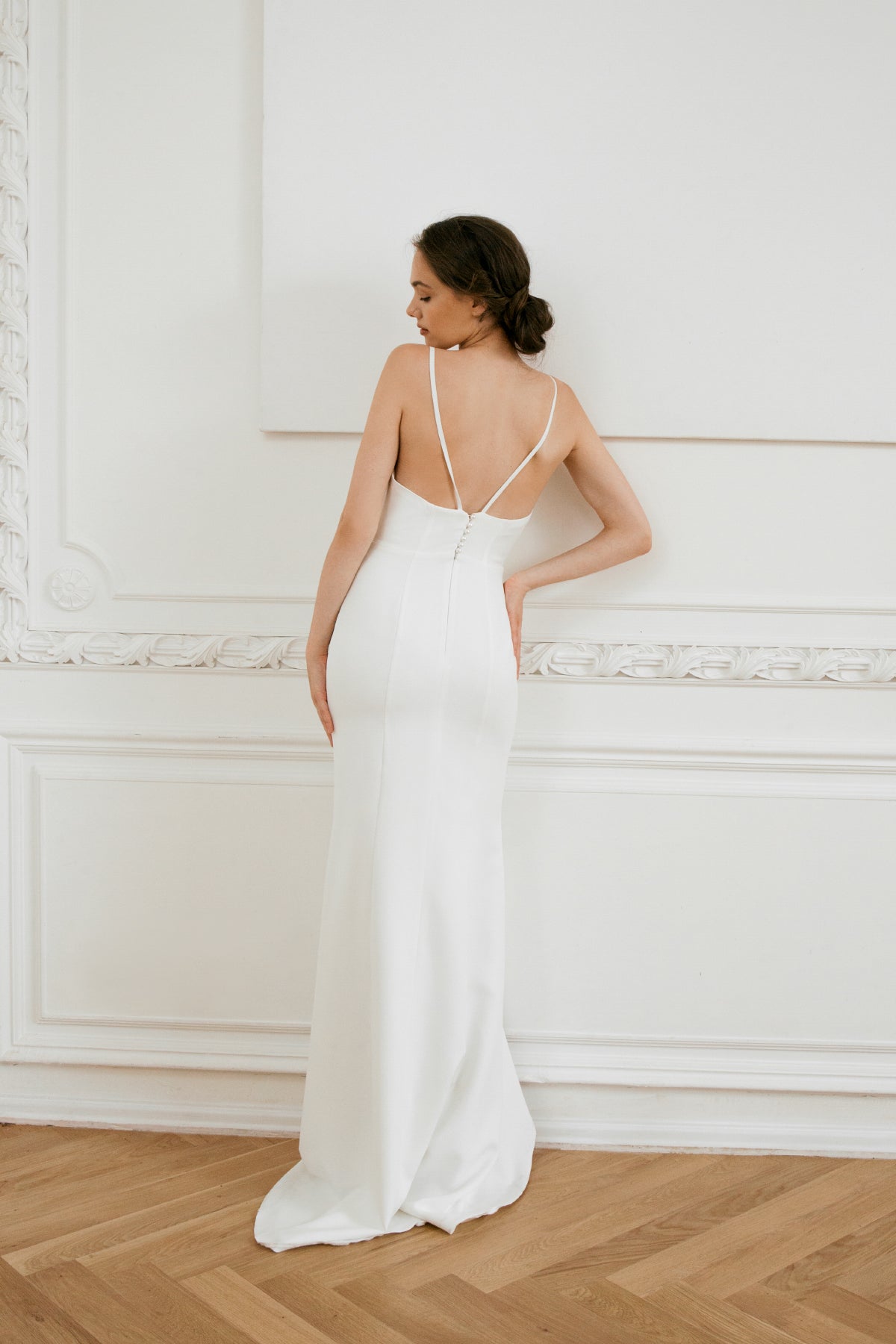 Back view of a fishtail wedding dress with covered-button closure and train
