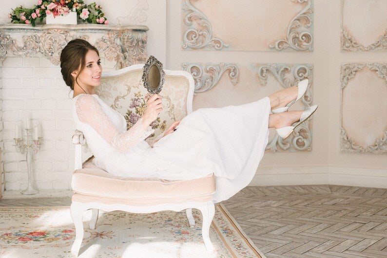 Bride reclining in Anna wedding dress with lace sleeves