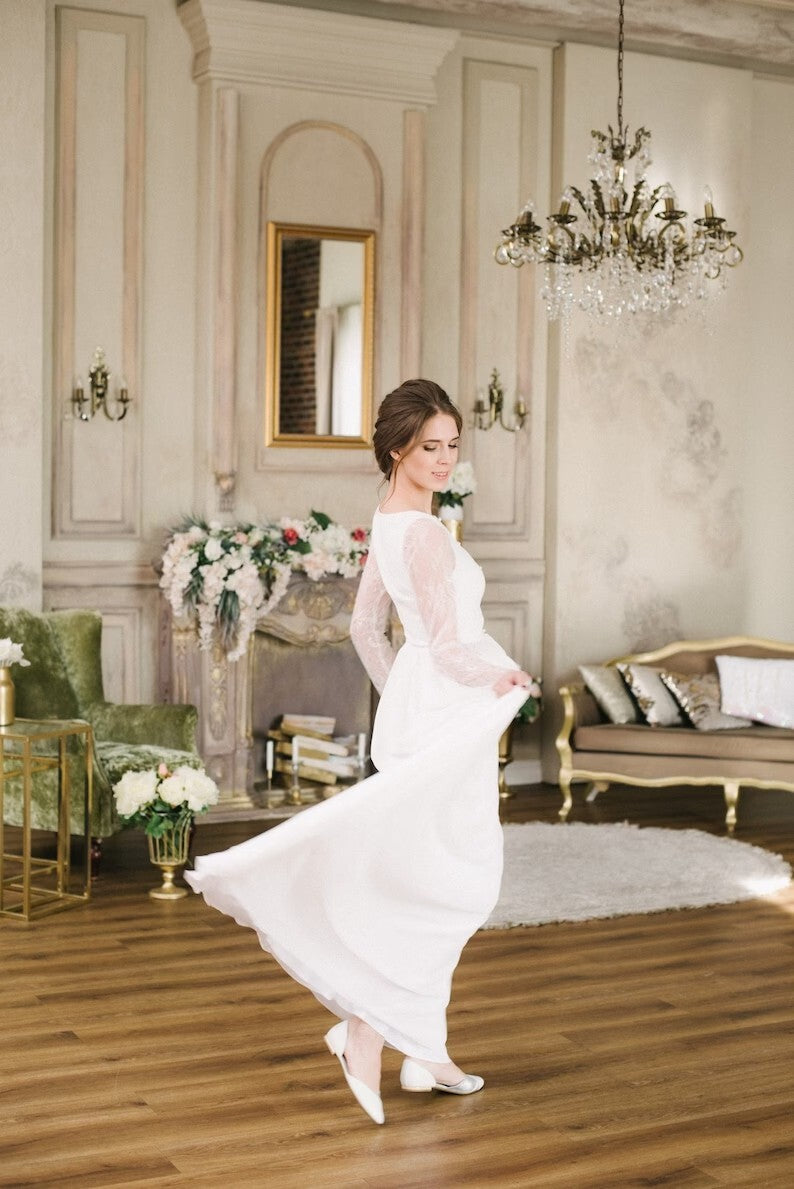 Bride holding the chiffon skirt of Anna wedding dress, side view
