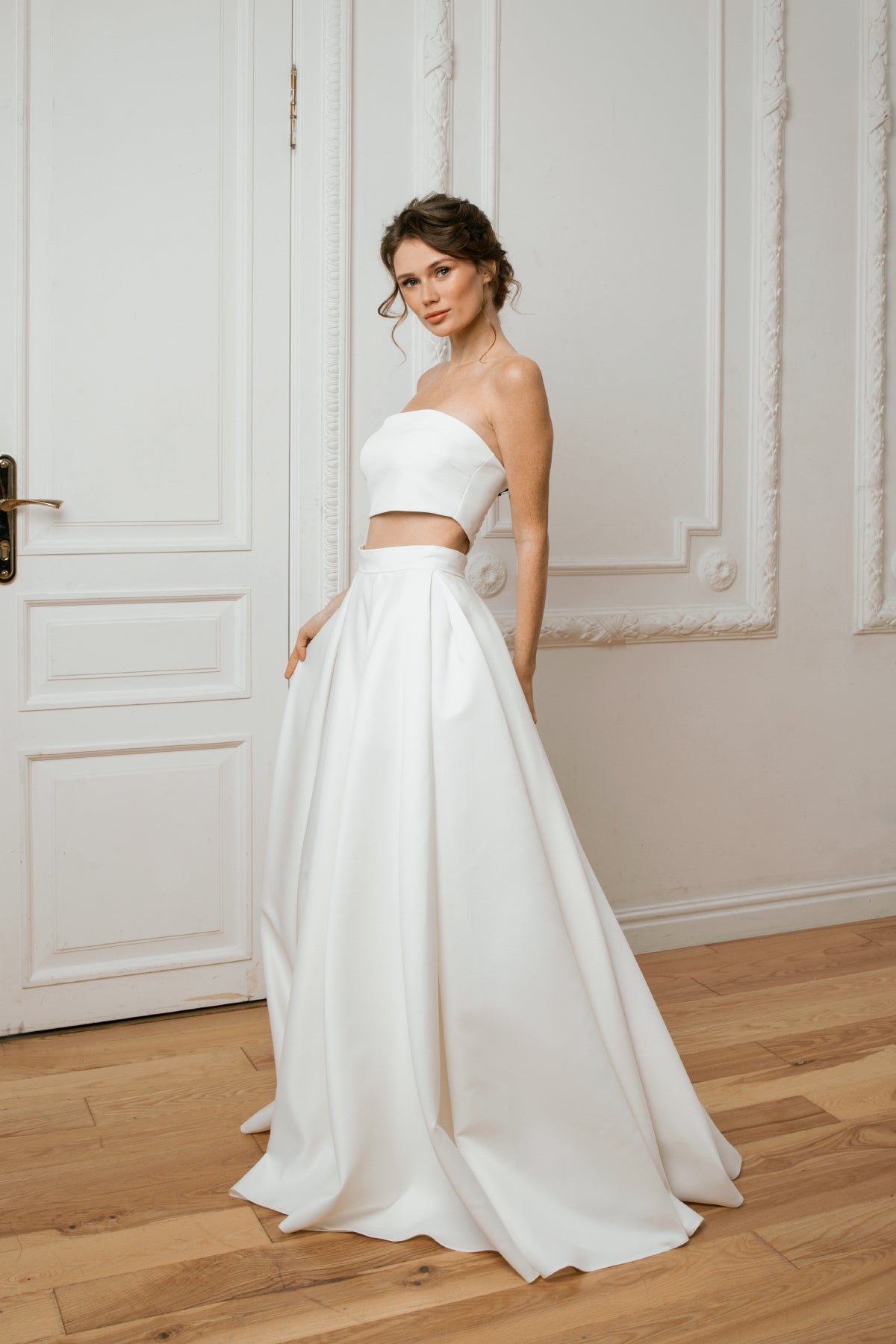Bride in a two-piece mikado wedding dress with a strapless crop top and full pleated skirt