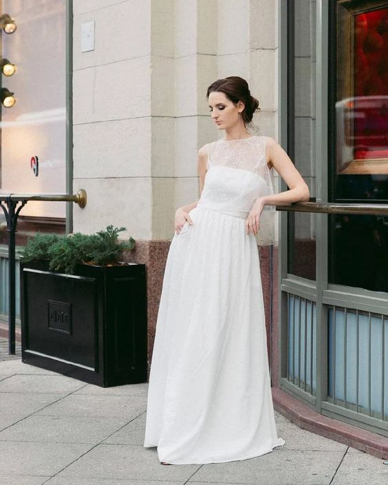 Aurora minimalist wedding dress worn in a city setting, full length