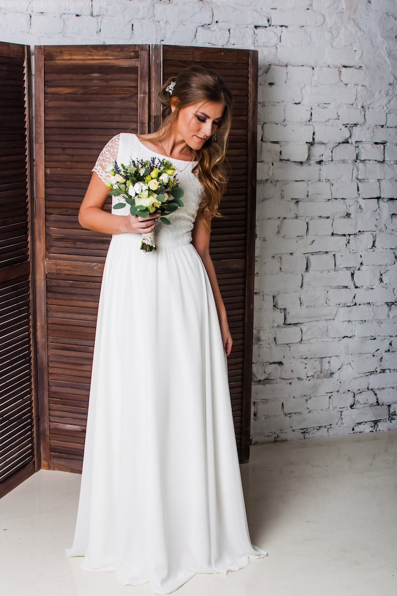Camille lace wedding dress, full length beside a wooden screen
