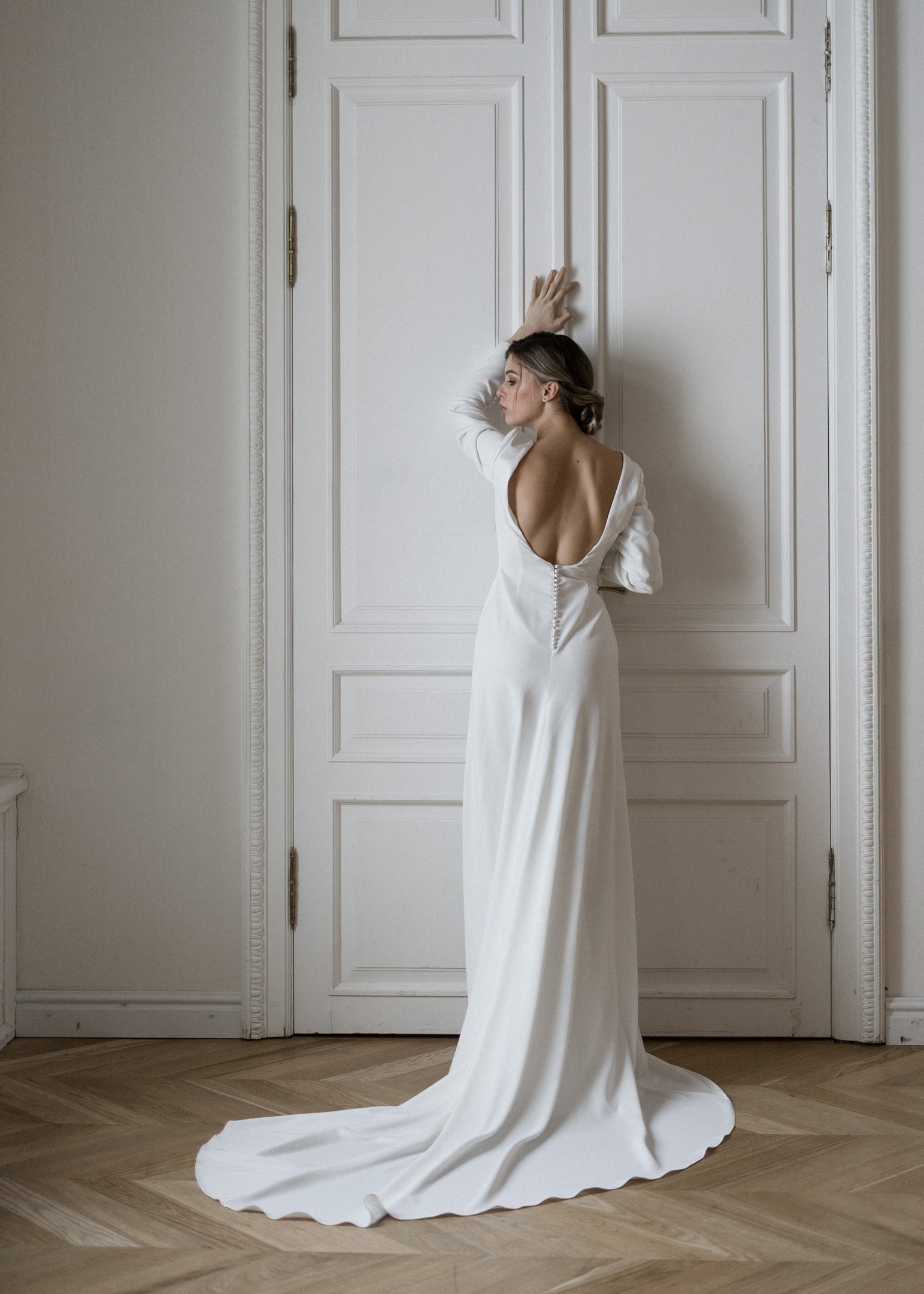 Colette open-back crepe wedding dress, back view with pearl buttons and train