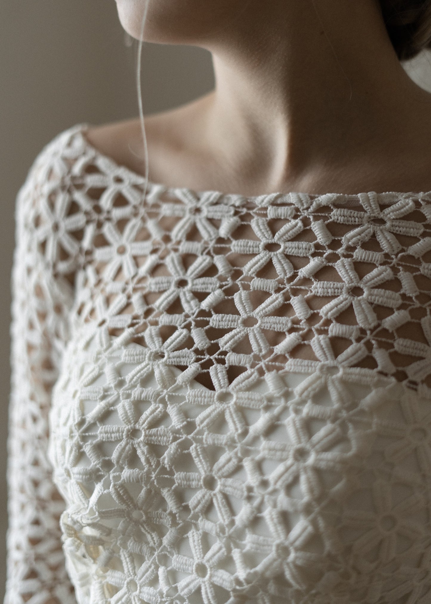 Close-up of the handmade floral crochet lace on Creme Flowers wedding dress