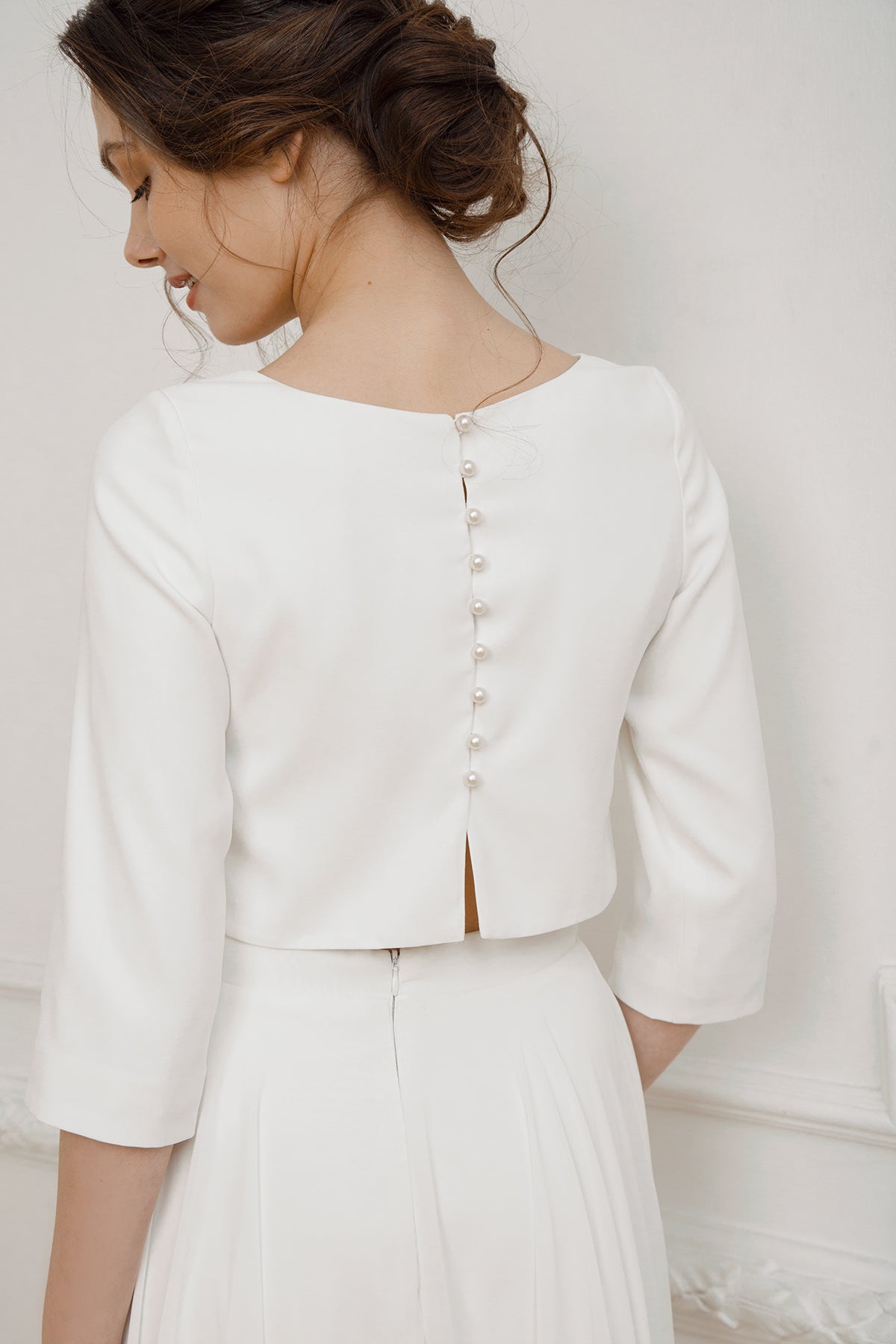 Pearl-button back detail on a crepe crop top