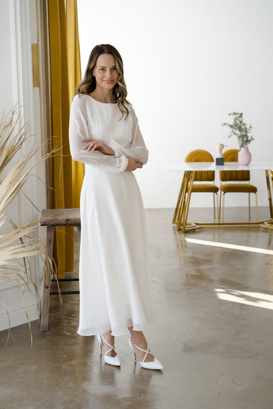 Bride in a long-sleeve midi chiffon wedding dress with a high neckline and A-line skirt