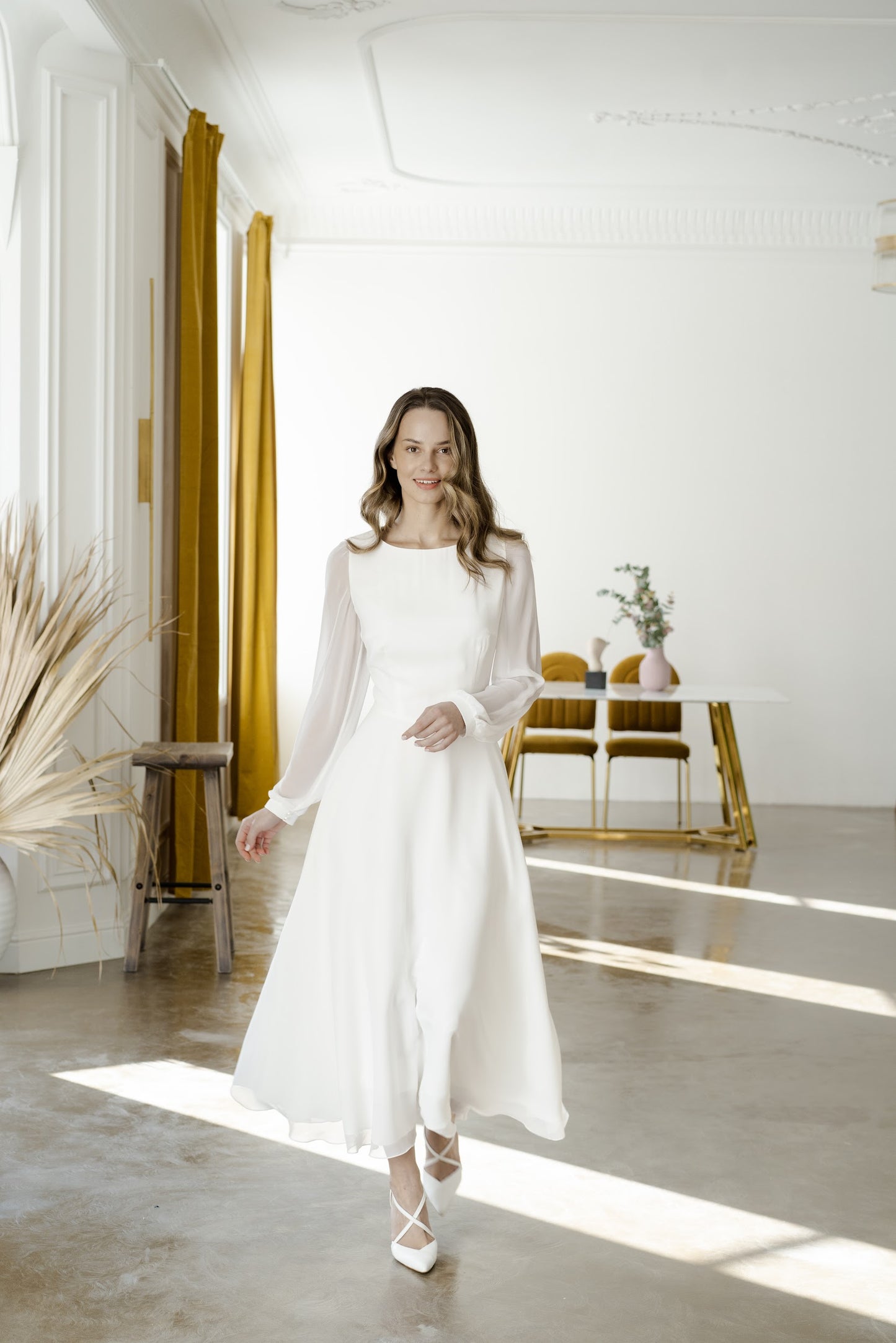 Bride in a long-sleeve midi chiffon wedding dress with the skirt in motion