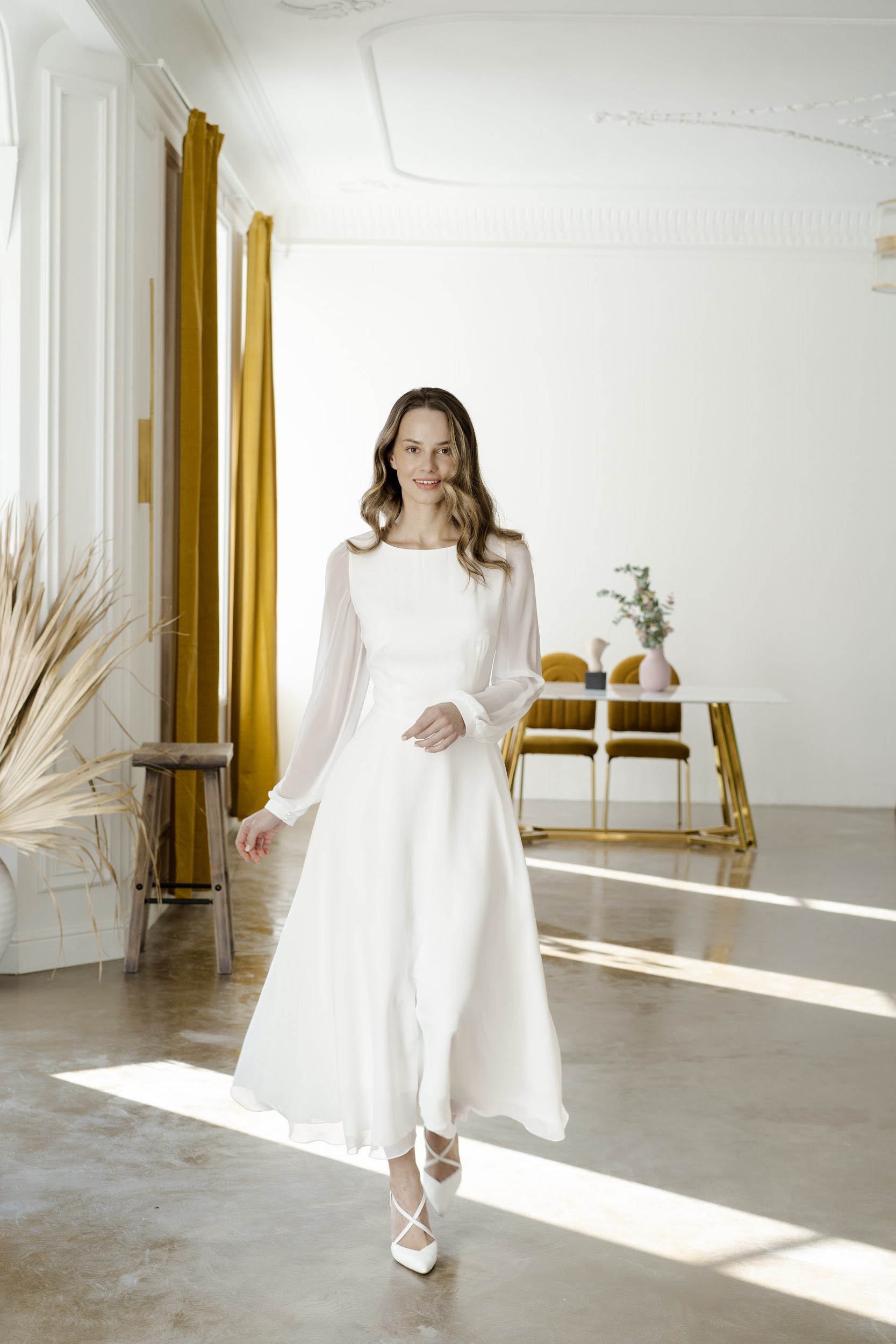 Bride in a long-sleeve midi chiffon wedding dress with the skirt in motion
