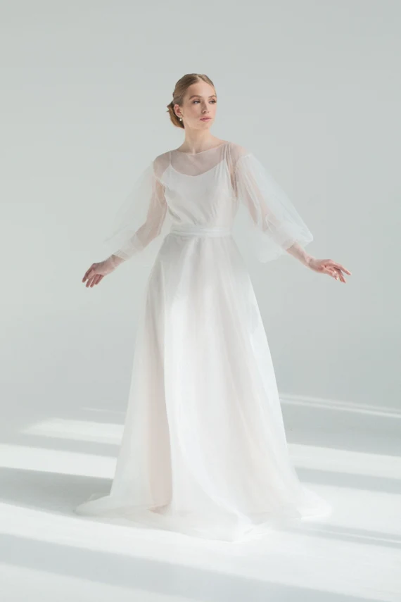 Kosmea wedding dress with arms open, showing the puff sleeves
