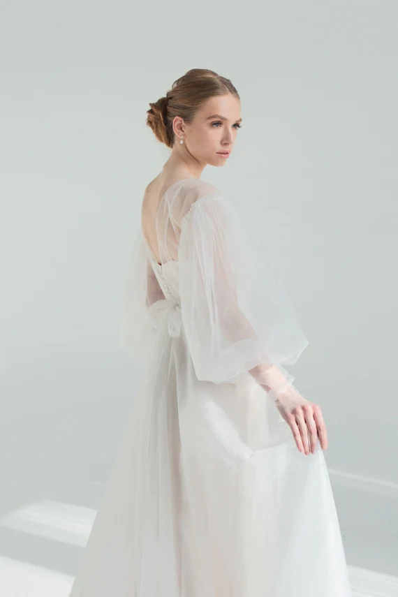 Kosmea sheer tulle wedding dress with puff sleeves over a satin slip, side view
