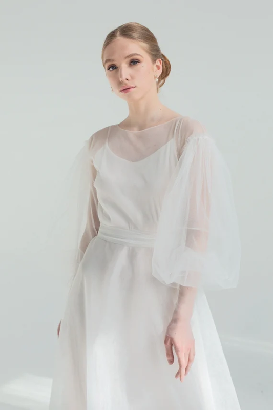 Bride in Kosmea puff sleeve wedding dress, three-quarter front view
