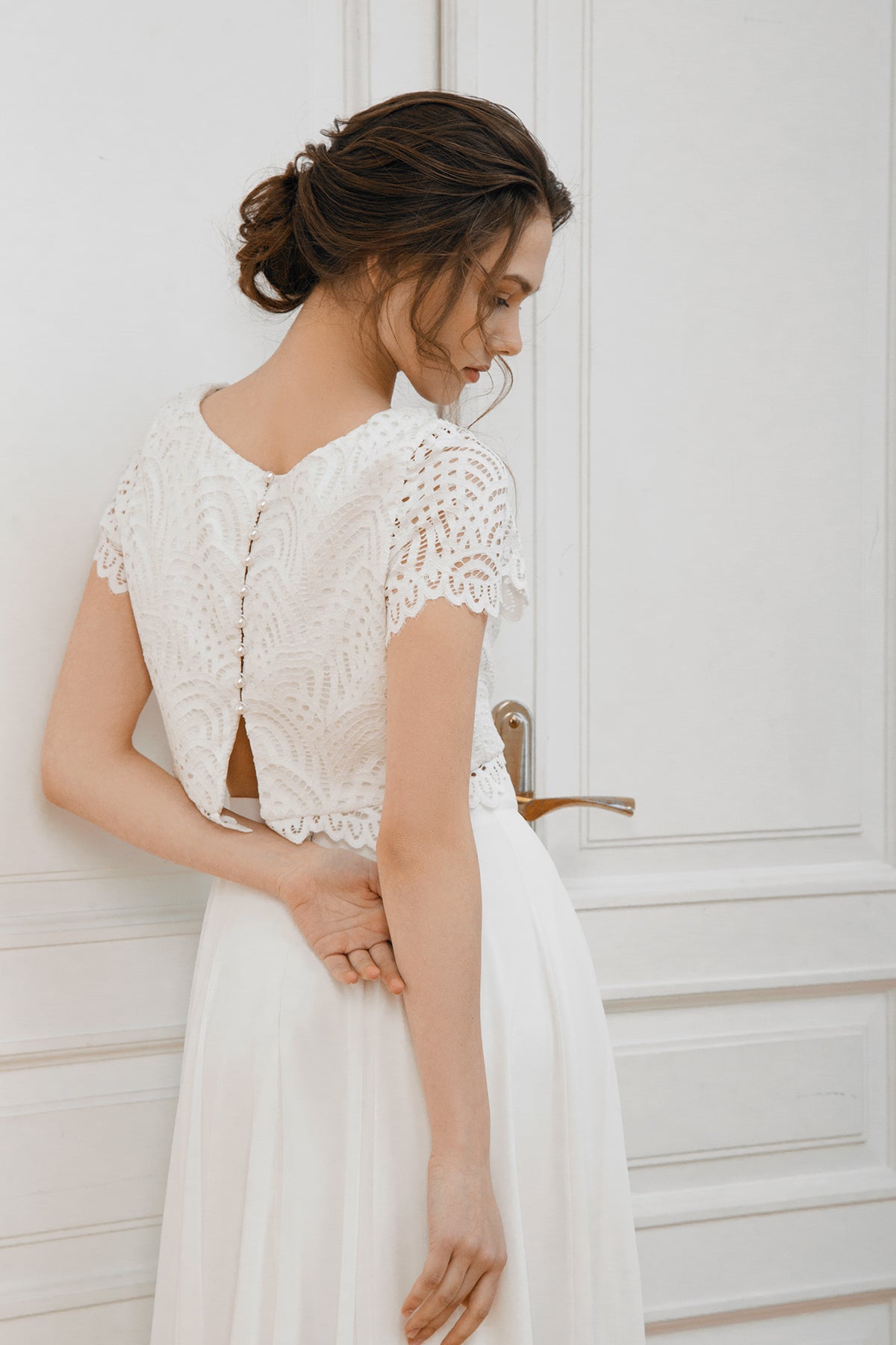 Side-back view of a scalloped lace crop top with a keyhole opening