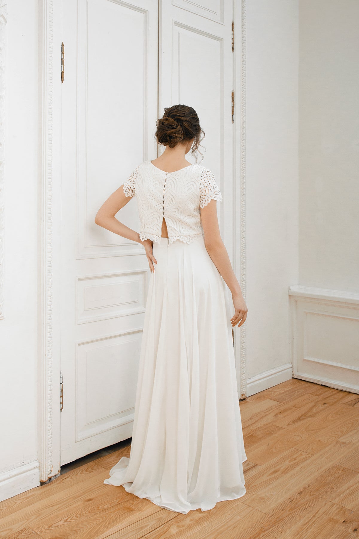 Back view of a two-piece lace and chiffon wedding dress with a high-low skirt