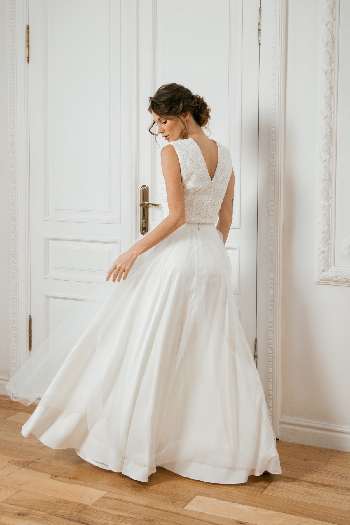 Back view of a two-piece lace and tulle wedding dress with a V-back crop top