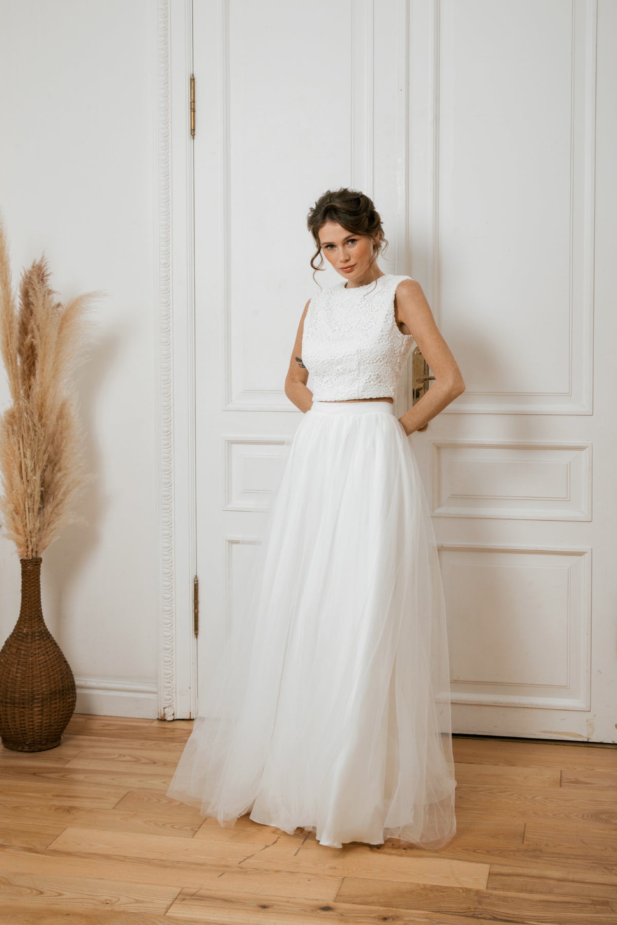 Bride in a two-piece lace and tulle wedding dress with a crop top and full skirt