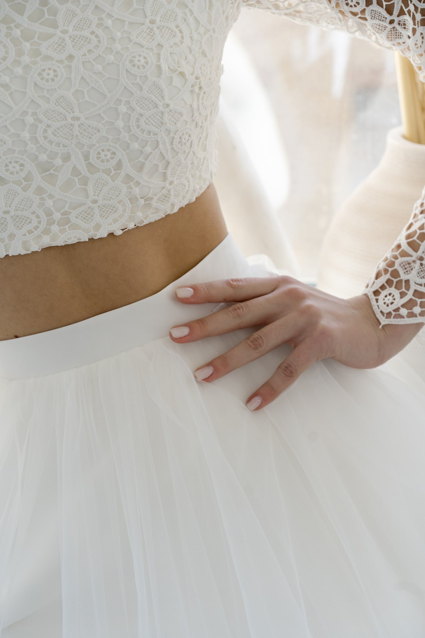 Detail of Margaux's bare waist between lace top and tulle skirt
