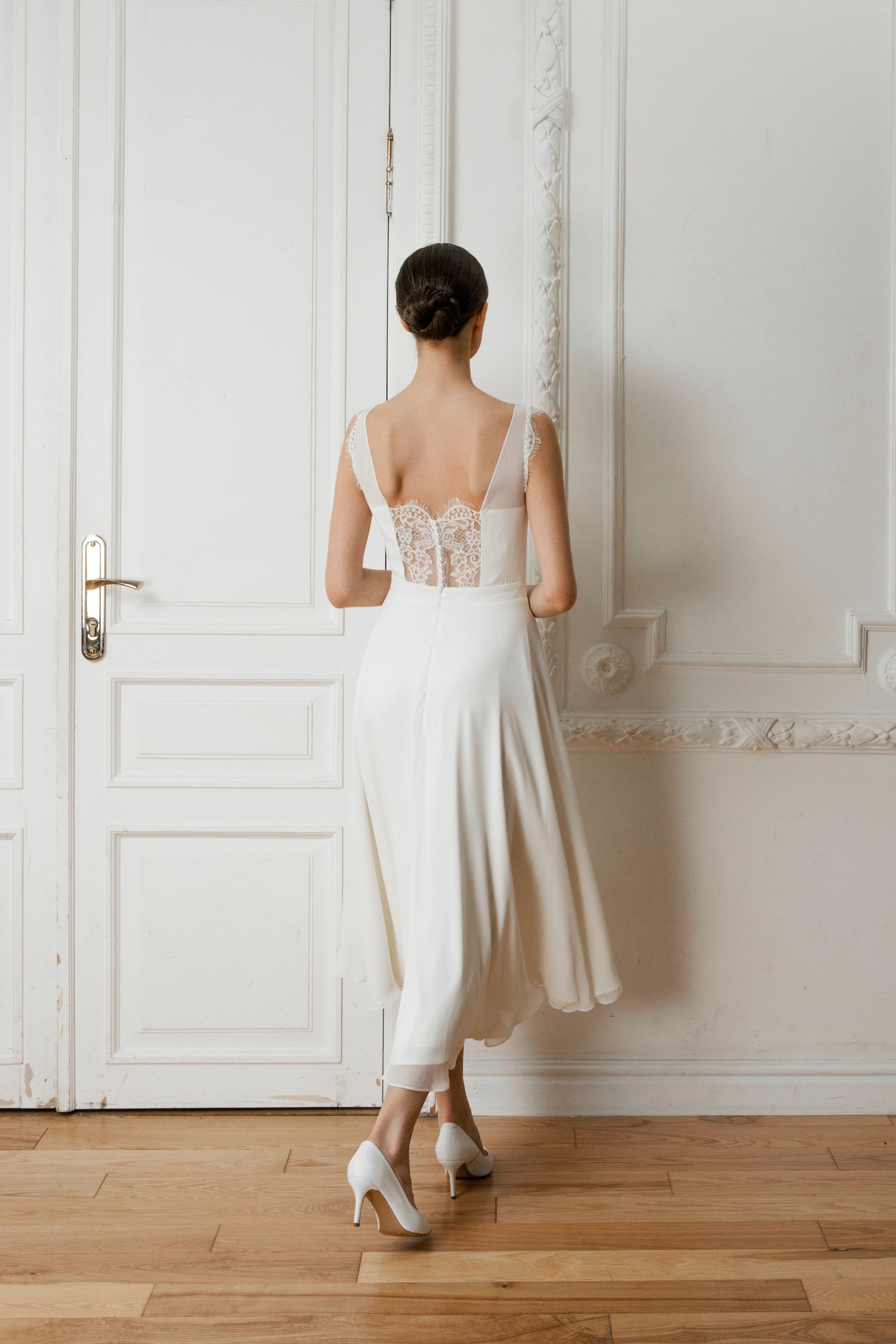 Back view of a midi wedding dress with a lace illusion back and A-line skirt