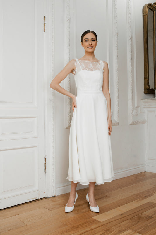 Bride in a midi royal crepe wedding dress with a lace illusion neckline and A-line skirt