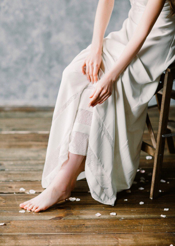 Bride seated in Moonlight wedding dress, showing lace bands at the chiffon hem