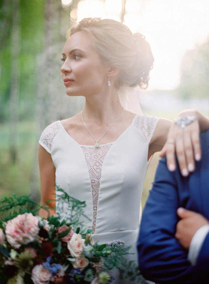 Bride in Moonlight lace wedding dress with cap sleeves, outdoor portrait
