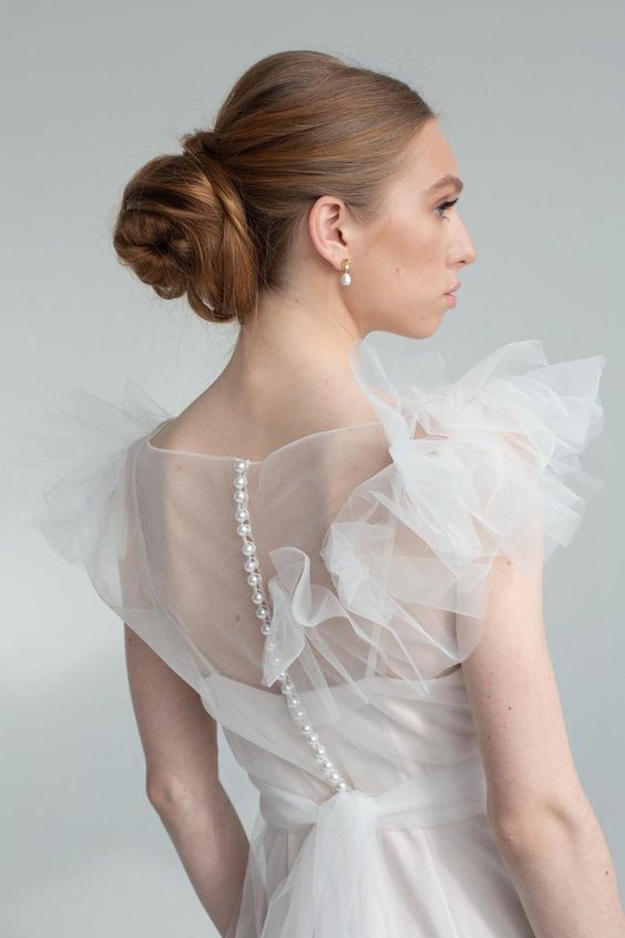 Back detail of Nicole wedding dress with covered buttons and illusion tulle panel