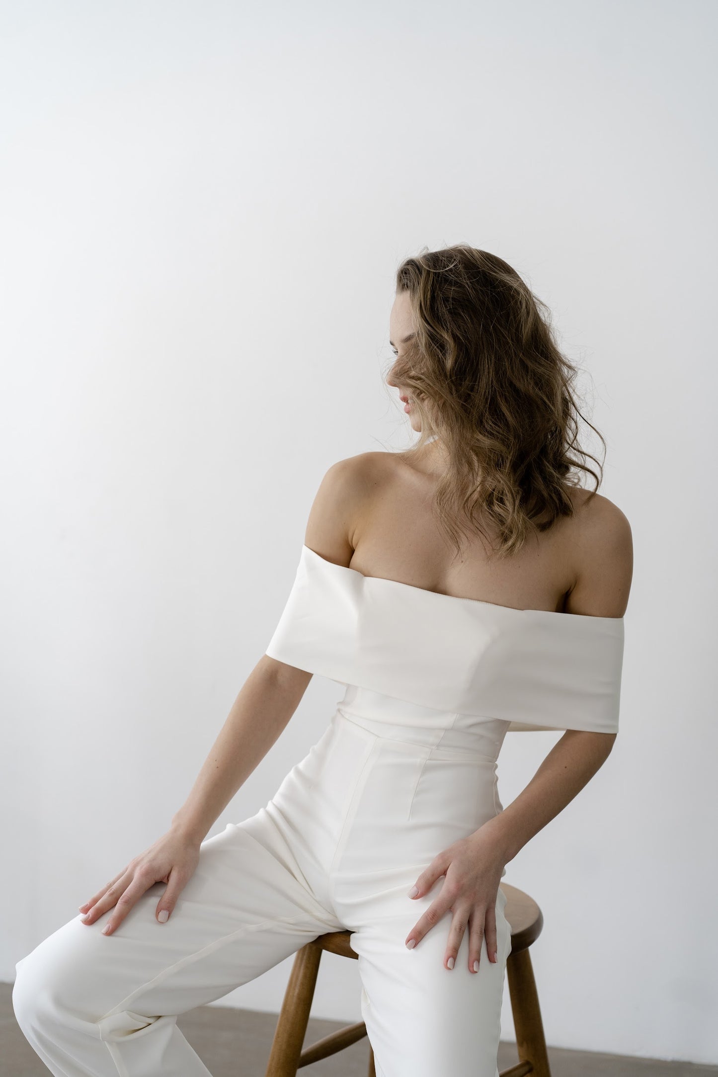 Off-the-shoulder royal crepe bridal jumpsuit, seated
