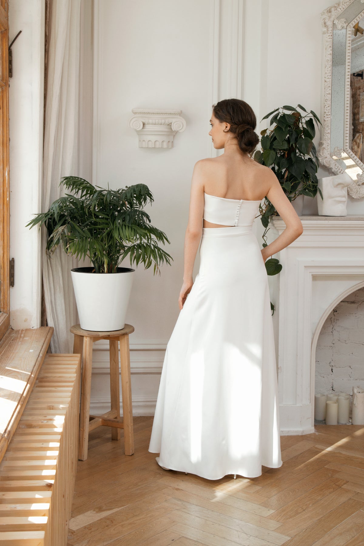 Back view of a two-piece wedding dress with a covered-button crop top and A-line skirt