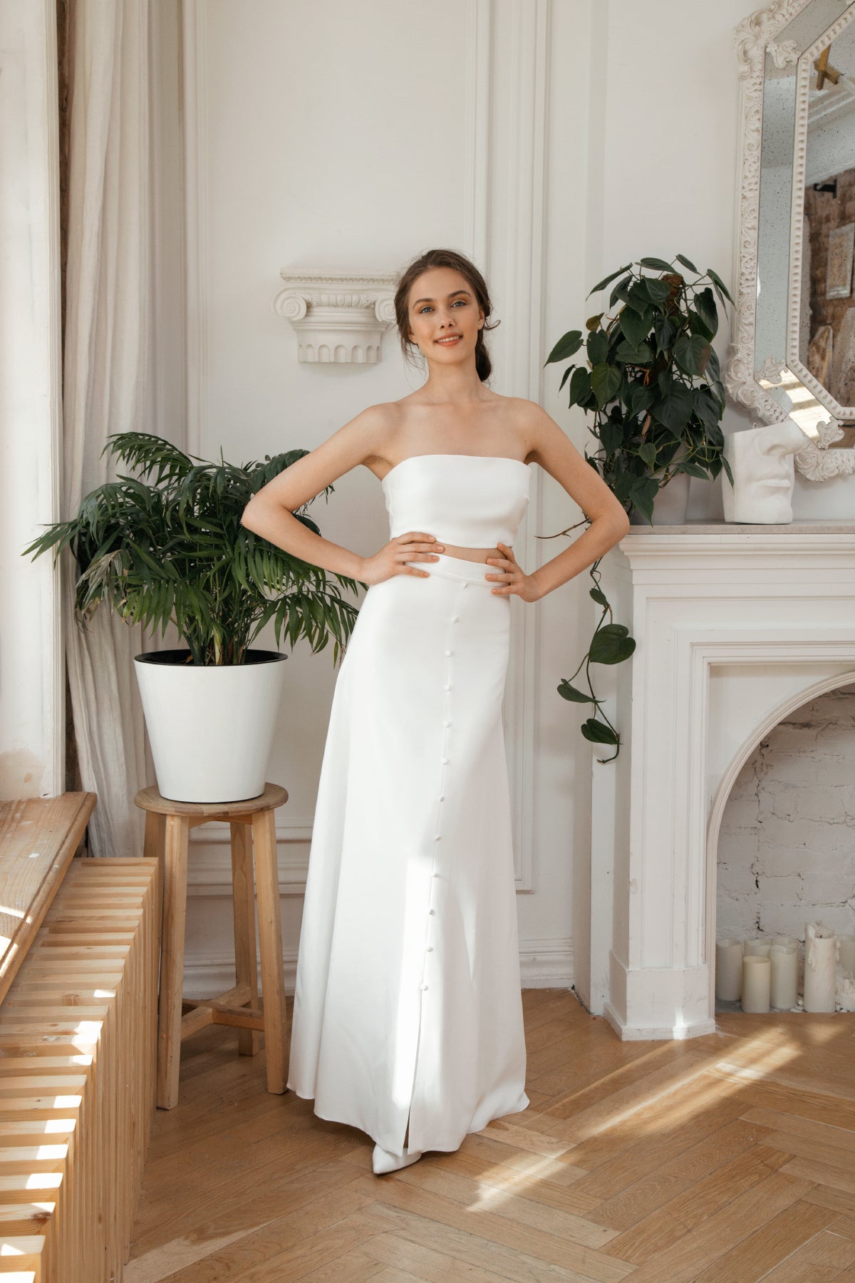 Bride in a strapless two-piece wedding dress with satin buttons down the skirt