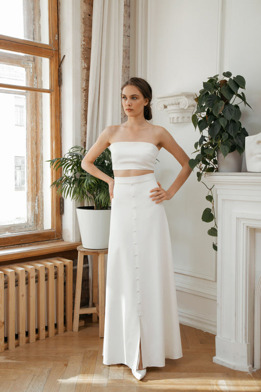 Bride in a two-piece wedding dress with a strapless crop top and long button skirt