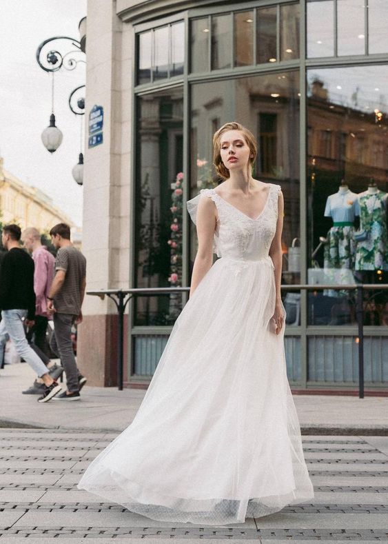 Whisper of the Wind wedding dress worn in a city street setting, full length