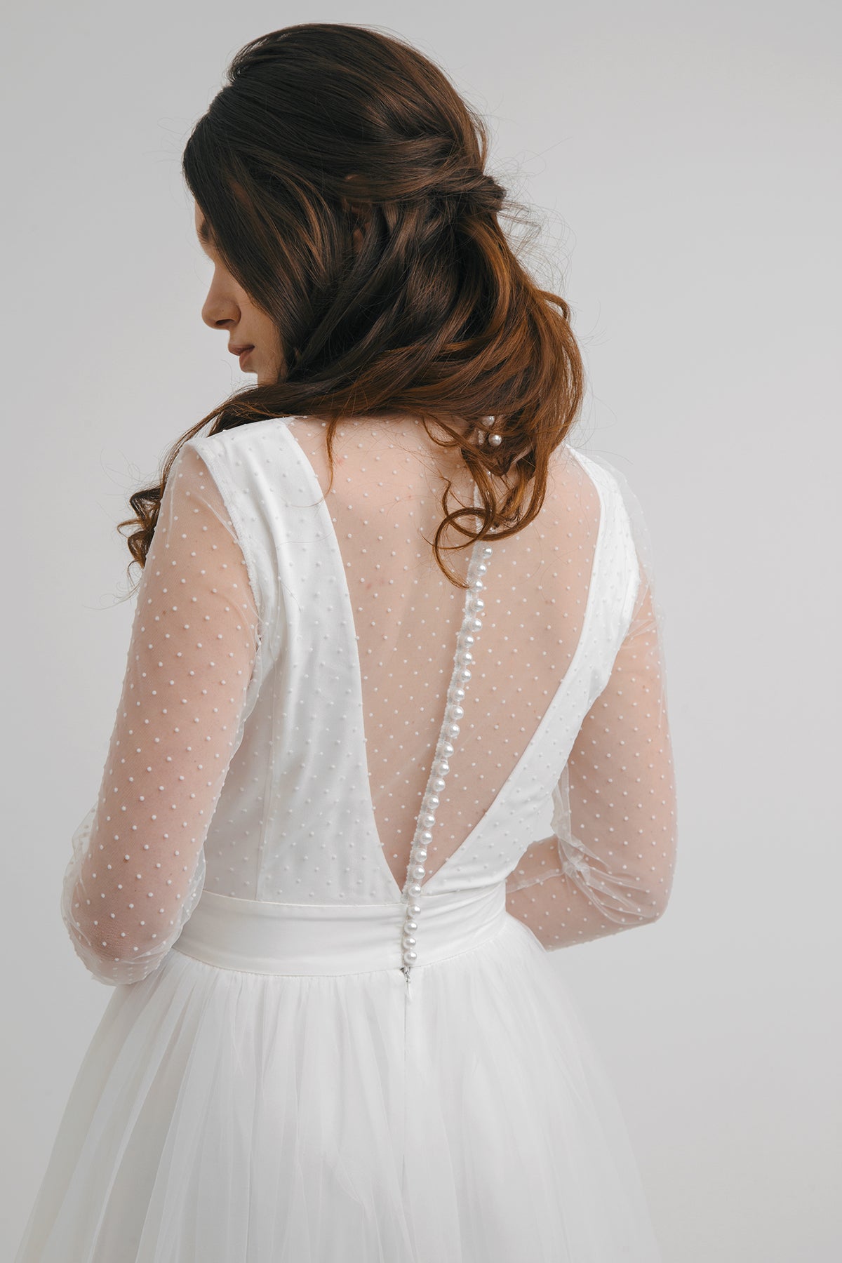 Back detail of White Orchid wedding dress showing polka-dot tulle and button closure