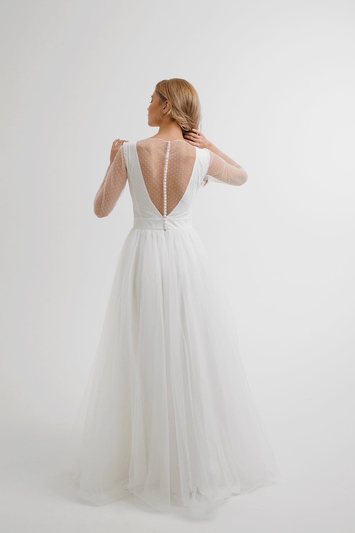 Back view of White Orchid wedding dress showing deep buttoned V back in polka-dot tulle